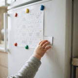 Il tabellone sul frigo, con la mano di un bimbo che sposta una carta